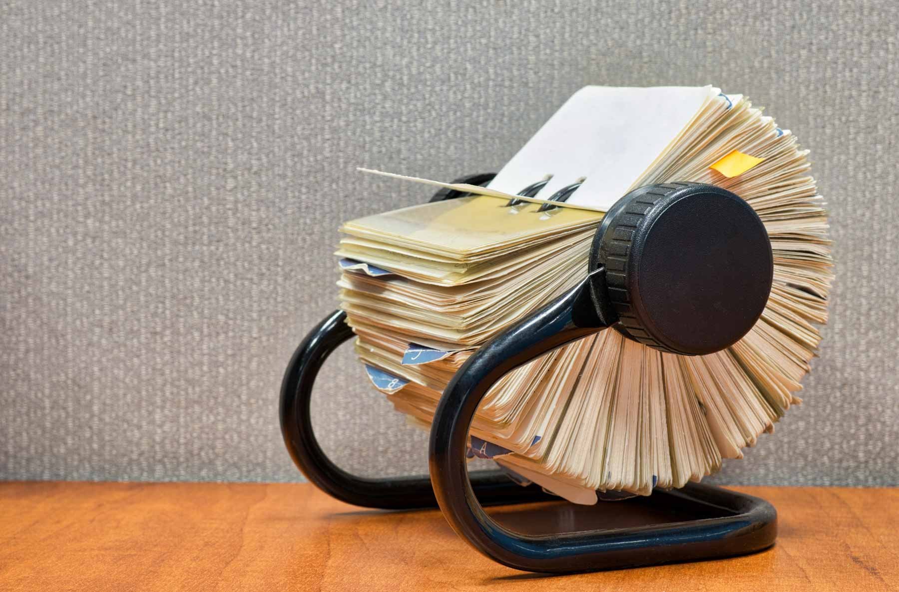 A vintage Rolodex filled with contact cards, symbolizing traditional customer management methods, now evolved into modern digital solutions like HubSpot's CRM for comprehensive customer relationship management.