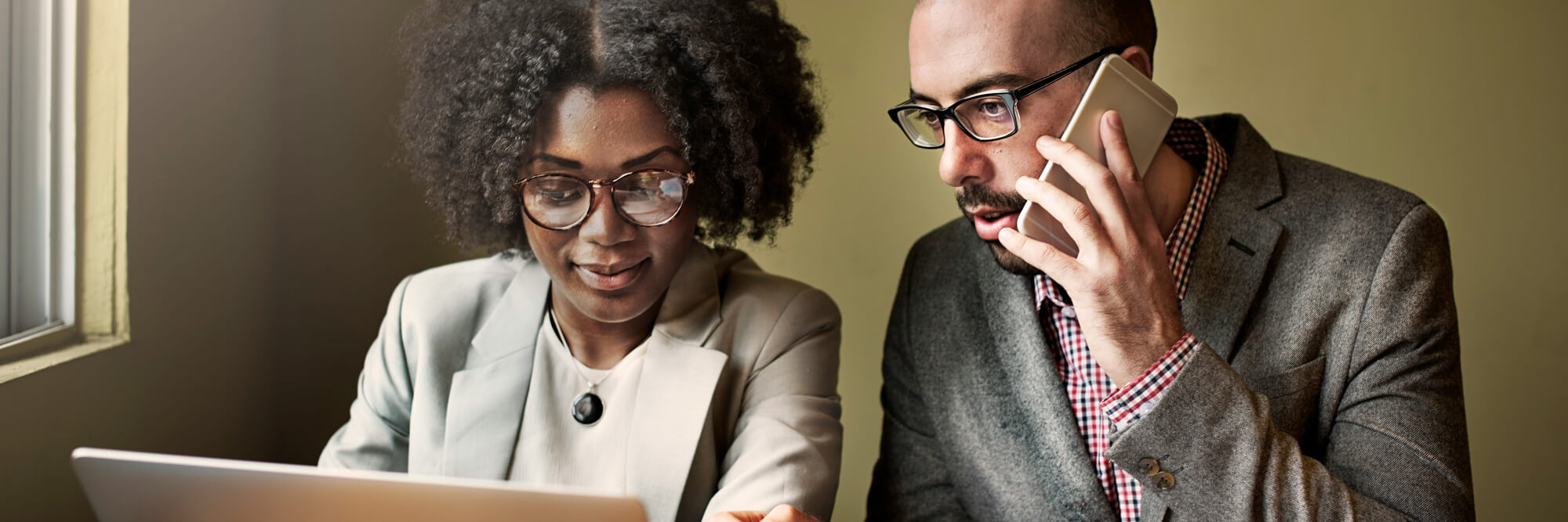 wo professionals reviewing work together at a desk
