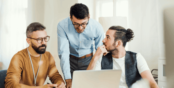Three professionals discussing SaaS marketing strategy in a working session