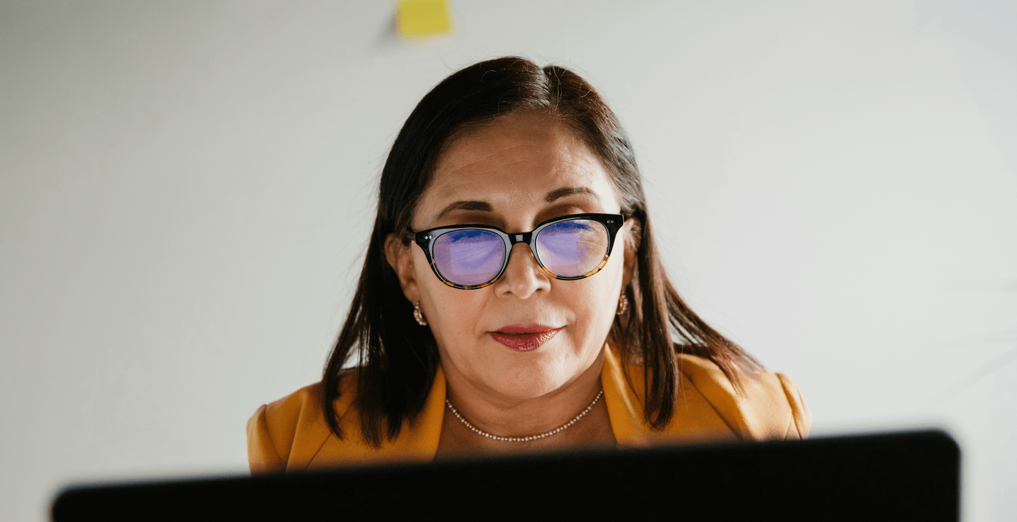 Business professional reviewing marketing strategy on her laptop in a modern office